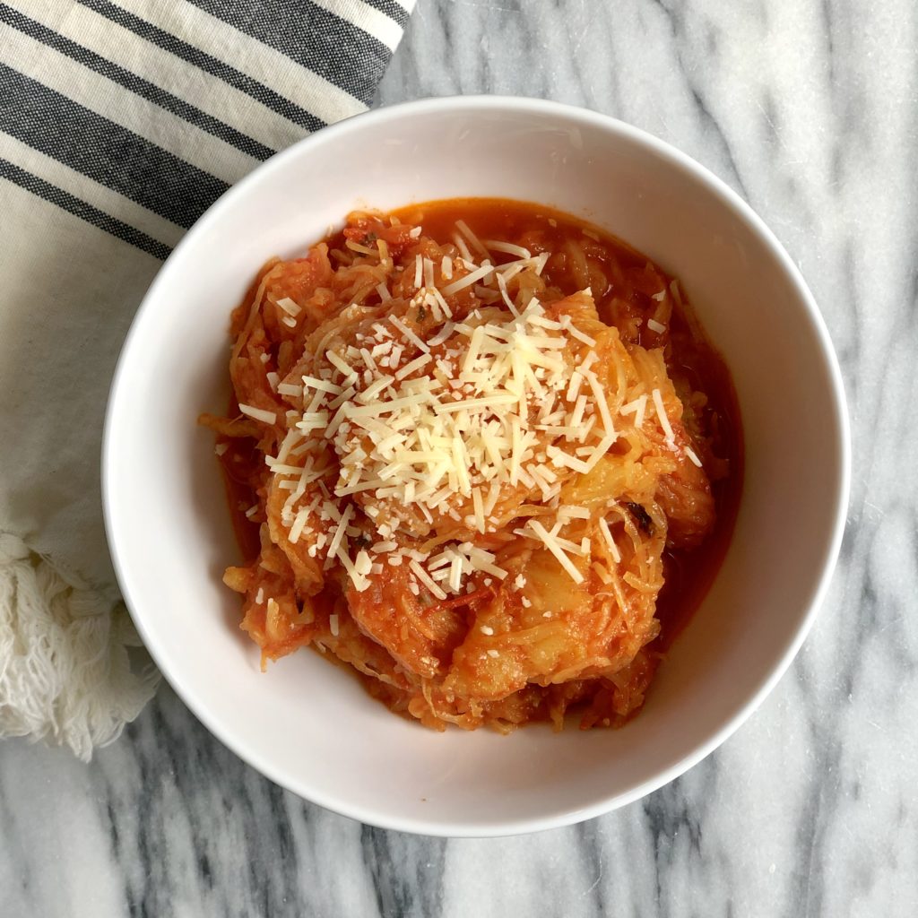Bowl of spaghetti squash pasta with homemade sauce topped with parmesan cheese.